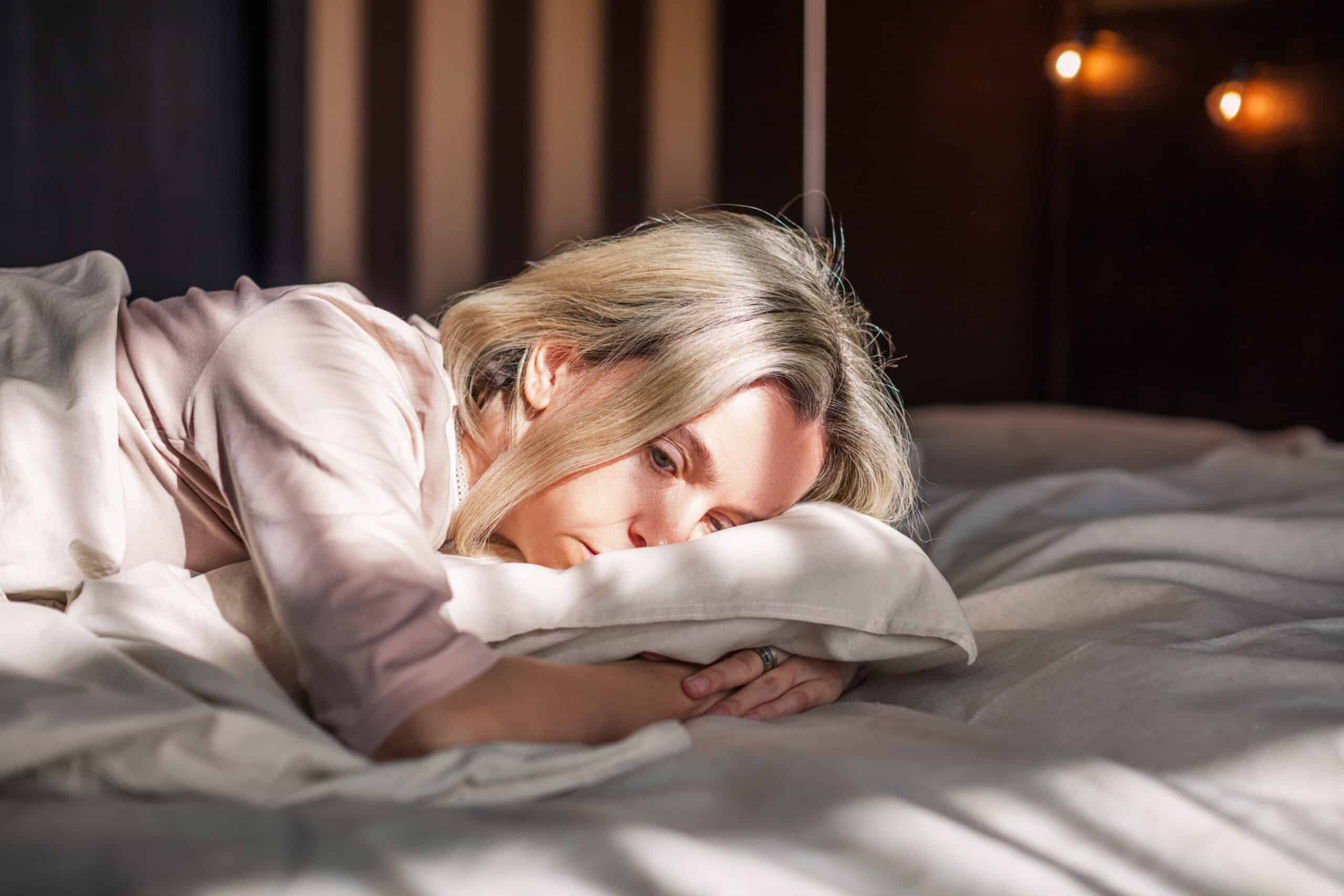 Exhausted woman on her bed at home.